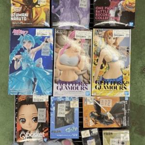 Assortment of anime figure boxes with price stickers arranged on a display rack, with plush toys at the bottom.