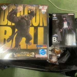 Dragon Ball merchandise box featuring a large Godzilla-like gorilla figure on a yellow background, with a black plastic bag beneath.