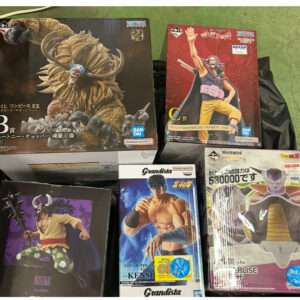 Boxed anime figure collection on a black bag, featuring a large horned beast on the left and a red-clad character on the top right, plus other figures.