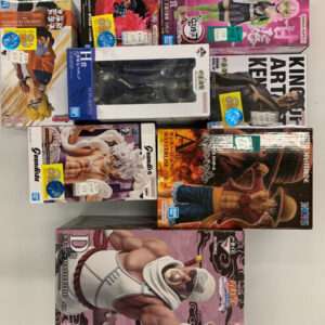 Boxed anime action figures stacked on a table, various character figures from popular series in colorful packaging