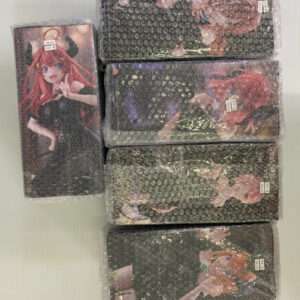 Stack of five anime figure boxes wrapped in bubble wrap, with a sixth vertical box showing a red-haired girl in a black outfit on the left, all on a light background.