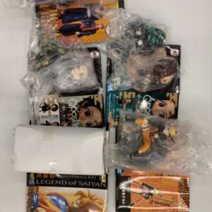 Pile of anime action figures and boxed merchandise wrapped in plastic bags, including Dragon Ball Z: Legend of Saiyan and other character figures