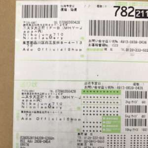 Close-up of a Japanese shipping label showing multiple barcodes, sender and recipient blocks, and green accents for a package.