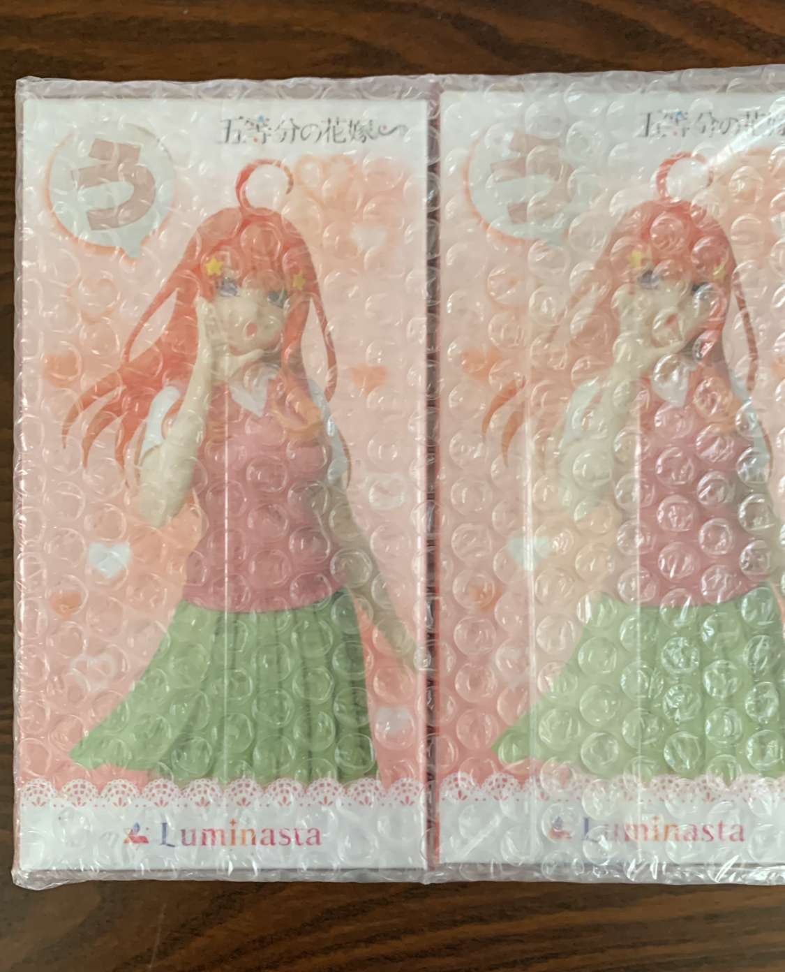 Img_2110 - Articulos Japan (post Box Japan) Two Luminasta figure boxes showing a pink-haired girl in a pink top and green skirt, covered in bubble wrap. Articulos Japan (Post Box Japan)