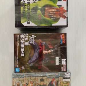 Stack of boxed anime figures: top box shows a Dragon Ball Z figure with a large green character, middle box features Naruto Shippuden Senju Hashirama, bottom row contains small wrapped figurines.