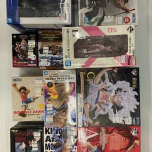 A collection of Japanese Ichiban Kuji and Bandai figure boxes stacked on a white surface, showing various character figures still in packaging.