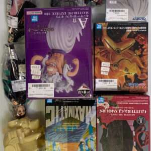 Assorted boxed anime figures and plastic-wrapped dolls on a display shelf, centered by a purple box with a muscular character.