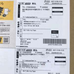 White sheet with multiple Japanese shipping label blocks, barcodes, and addresses; a yellow ad with a small black cat on the left edge.