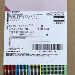 Close-up of a white printed shipping/receipt label with Japanese text, a barcode, and a color swatch grid at the bottom.