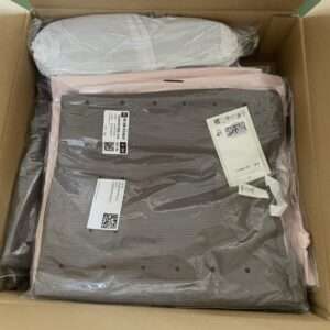 Box containing a gray striped rectangular item wrapped in plastic with packing labels attached.