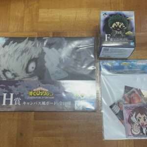 My Hero Academia merchandise laid on a wooden floor: a large canvas board featuring a fierce character, plus two boxed figures and a small card pack in plastic bags.