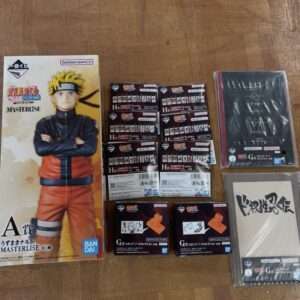 Naruto Masterlise A賞 figure box with Naruto in orange jumpsuit, plus multiple accessory boxes and booklets laid out on a wooden floor