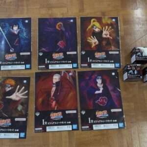 Collection of Naruto Shippuden character visual sheet sets in plastic wrap arranged on a wooden floor.