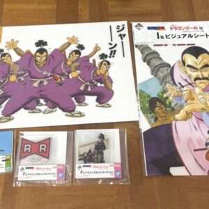 Dragon Ball merchandise laid on a wooden floor: two large posters (one with purple-clad fighters, one with a large villain figure and Goku) and several boxed card sets nearby.
