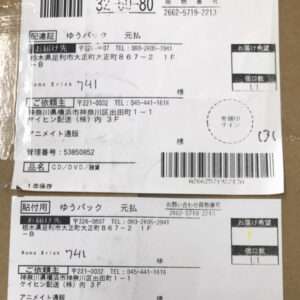 Two Japanese shipping labels with barcodes on a cardboard box, showing sender and recipient addresses and the handwritten number 741.
