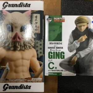 Two boxed action figures side by side: on the left a muscular figure wearing a pig mask from Grandista, on the right Ging Freecss from Hunter x Hunter in a white outfit with a scarf.