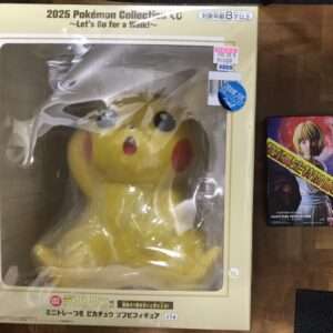 Large Pikachu plush toy in a beige display box with packaging text, visible through clear plastic window.
