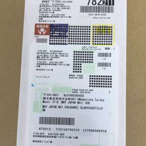 Japanese parcel shipping label on a brown box with multiple barcodes, address blocks, and handling icons