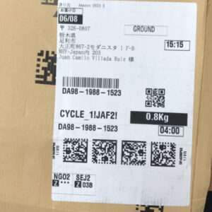 Box with a white shipping label showing destination in Japan, barcodes, QR codes, and a weight of 0.8 kg.