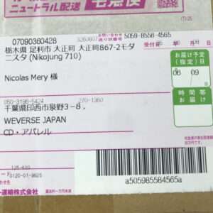 Shipping label on a cardboard box showing sender and recipient in Japanese, plus a barcode.