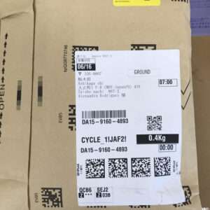 Brown cardboard parcel with a white shipping label showing date 06/16, Ground shipping, 0.4 kg, plus barcodes and QR codes.