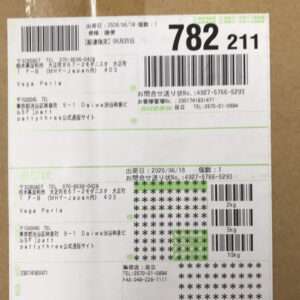 Shipping label on a brown box with multiple barcodes, Japanese text, and tracking numbers visible