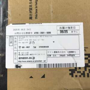 Cardboard box with a white shipping label showing delivery date 06/25 and Amazon.co.jp details, including a barcode and tracking numbers.