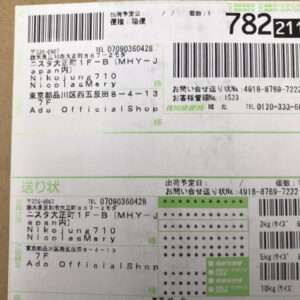 Close-up of a Japanese parcel shipping label showing multiple barcodes, tracking numbers, and sender/recipient addresses in Japanese.