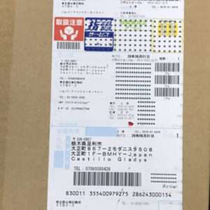 Shipping label on a brown cardboard box, with multiple barcodes, tracking numbers, and Japanese text.