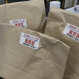 Brown paper bags with white labels featuring red Japanese text, likely prize bags for a drawing.  Articulos Japan (Post Box Japan)