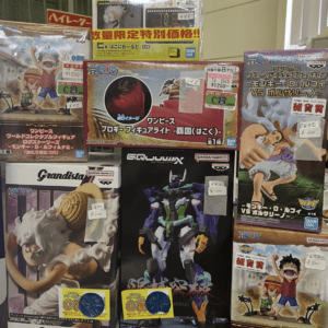 Storefront display of boxed anime/action-figure sets, including One Piece characters, with price stickers on the boxes.