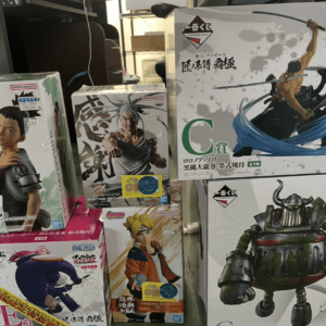 Stack of boxed anime figure collectibles on a display shelf, featuring characters from Naruto, One Piece, and more (various sizes).