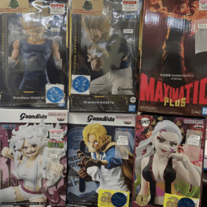 Six boxed anime figure boxes on a store shelf, featuring Dragon Ball and One Piece characters with price stickers visible.