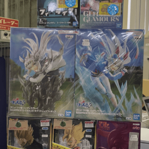 Display of multiple boxed anime figures on a shop shelf, including One Piece and Dragon Ball characters with price stickers on boxes.