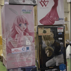 Stacked boxes of anime figurines on a store display, showing various female characters in glamorous outfits there for sale.