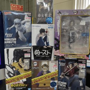 Display of boxed anime figures on a shelf, featuring Naruto, My Hero Academia, and Demon Slayer characters with price tags visible.