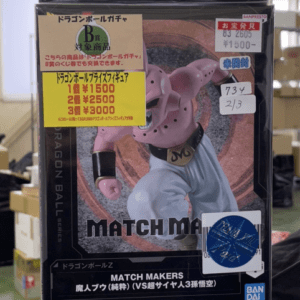 Stack of three Dragon Ball Match Makers figures in their boxes on a store shelf, with Goku on the top box, a second figure in white and pink/yellow tones, and Shenron from Dragon Ball History Box on the bottom box, all display-boxed for sale in a shop.  Articulos Japan (Post Box Japan)