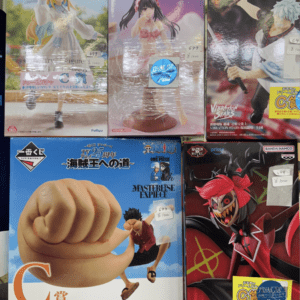 Rows of colorful anime figure boxes on a store shelf, featuring characters from One Piece and other series.