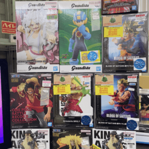 Display of boxed Grandista anime figures on a store shelf, featuring One Piece and Dragon Ball characters with bright packaging and price stickers.