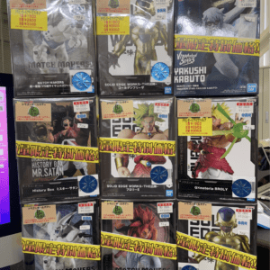 Rows of boxed Dragon Ball and Naruto figures on a store shelf with yellow sale tags and price stickers, front view.
