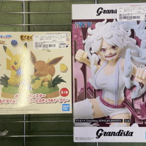Two boxed anime figures on a wire rack: a Pikachu and Eevee set on the left and a Grandista Jewelry Bonney figure on the right (Bandai).