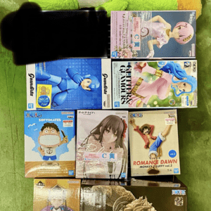 Tall green plush toy on a shelf with various anime figure boxes displayed below.