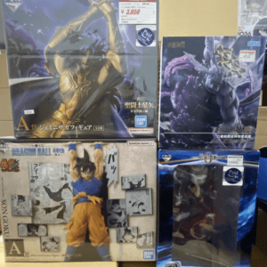 Display of boxed anime figures on a store shelf, including Saint Seiya and Dragon Ball/Bandai Namco figures in dynamic poses.