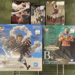 Row of boxed anime action figure sets on a metal grid display shelf, including One Piece titles among others in the collection.