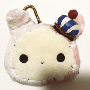 Cute plush keychain with a round cream face and tiny blue-striped hat with a brown band.