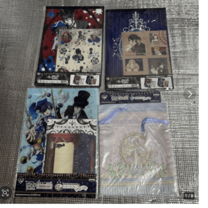 Set of anime-themed merchandise: four colorful packaging panels with character illustrations, decorative patterns, and a pastel gift bag in the foreground on a textured surface.