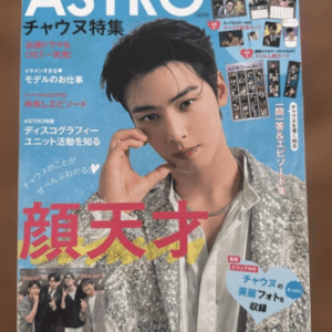 Magazine cover for ASTRO featuring a young man in a silver jacket posing with a hand near his face; bold pink Japanese text across the lower left and various smaller captions and photos around the edges.
