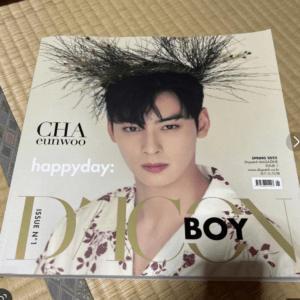 Magazine cover featuring a male model with a twig crown, wearing a floral shirt, on a pale background with the word 'happyday' text visible (Spring 2022).