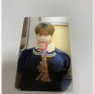 Young man taking a casual selfie indoors, holding a pink mug close to his face and wearing a dark sweater with a striped scarf.