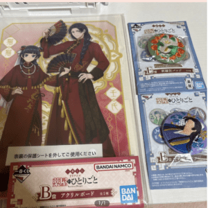 Two anime characters in red traditional outfits holding fans, posed against a pink and gold decorative background.